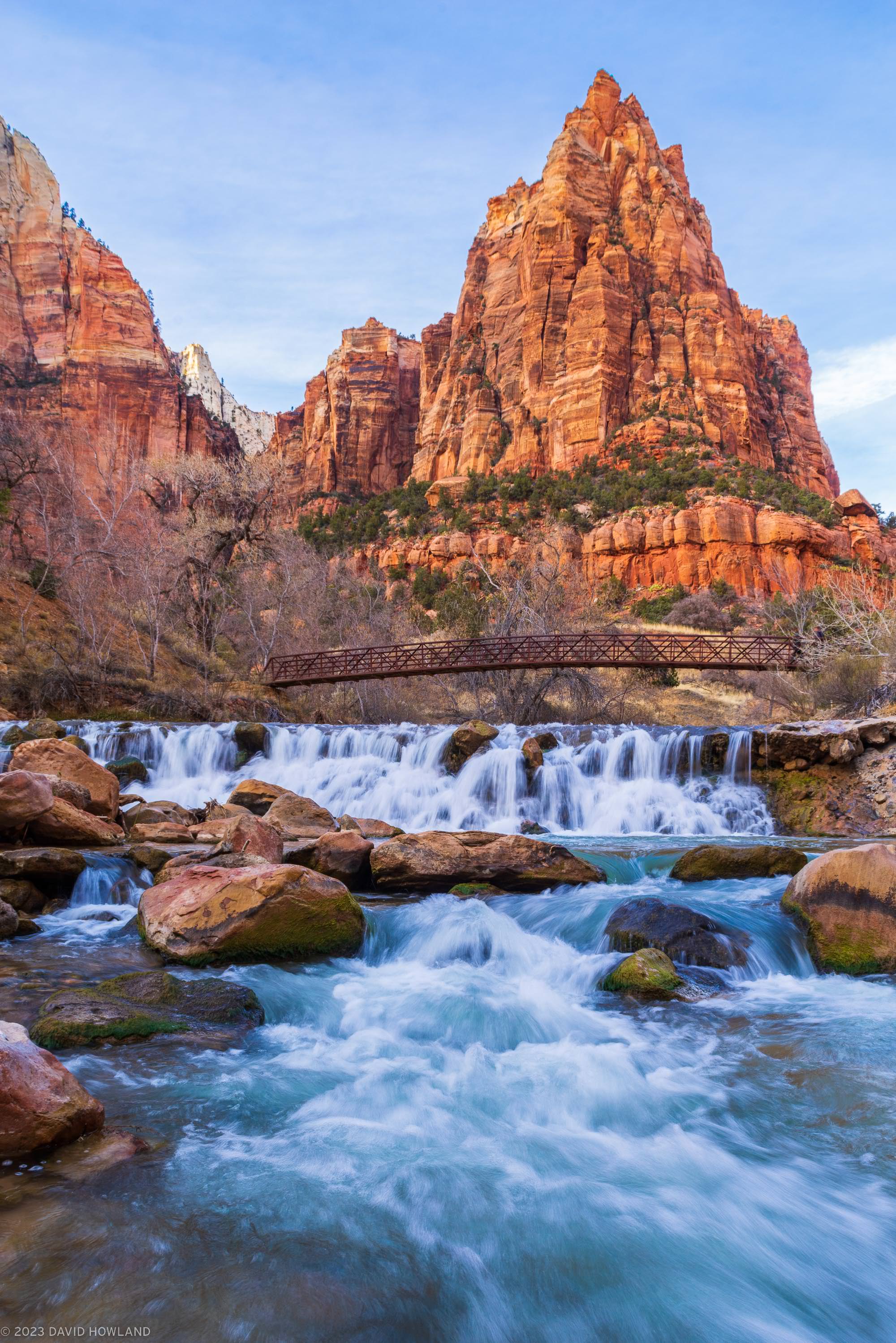 A photo of a waterfall in front of the towering rock walls of Zion National Park in Utah.