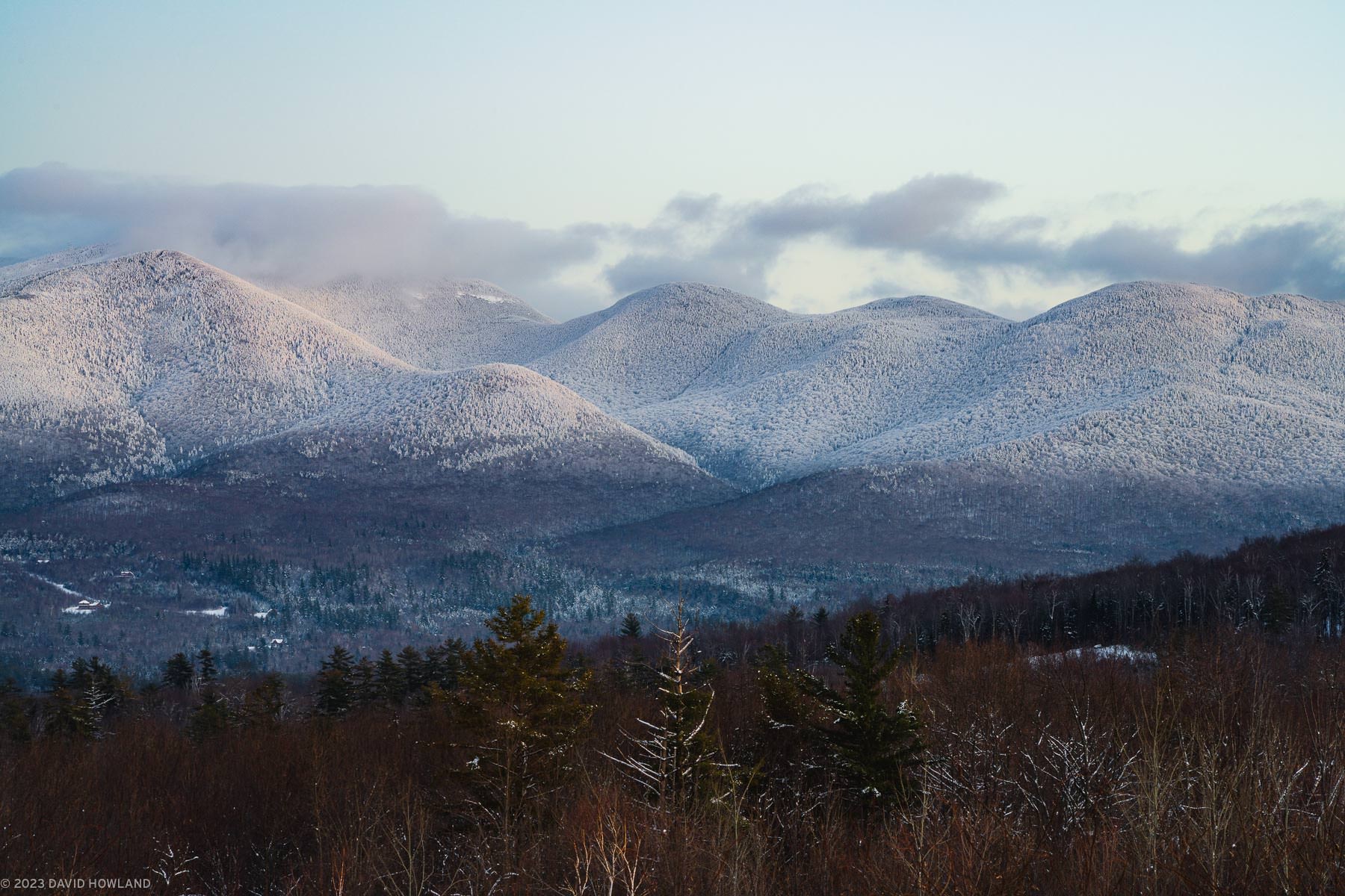 A photo of the snow covered Cannonballs and Cannon Mountain at dusk