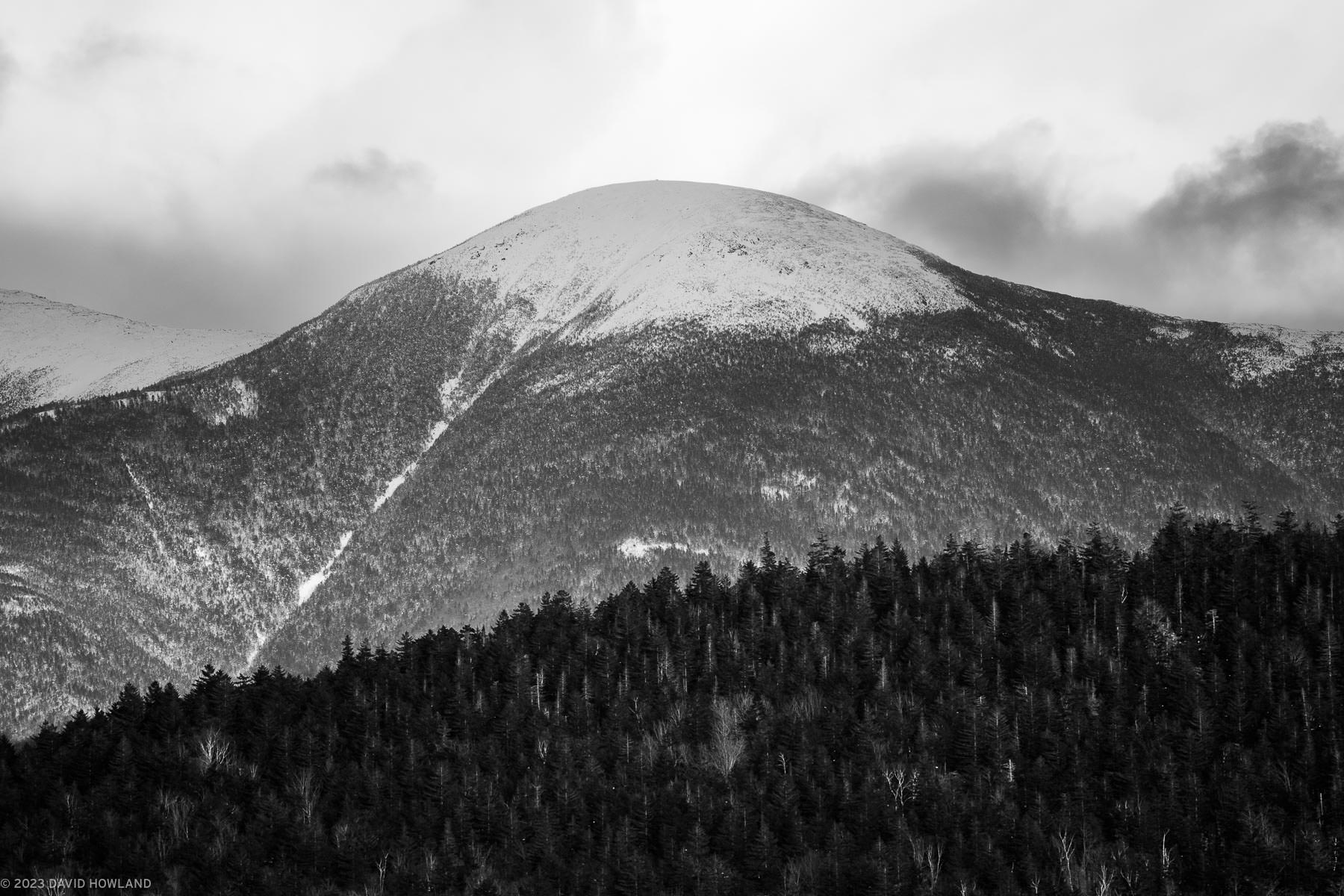 A black and white photo of snow-covered Mount Eisenhower in the Presidential mountain range of New Hampshire.