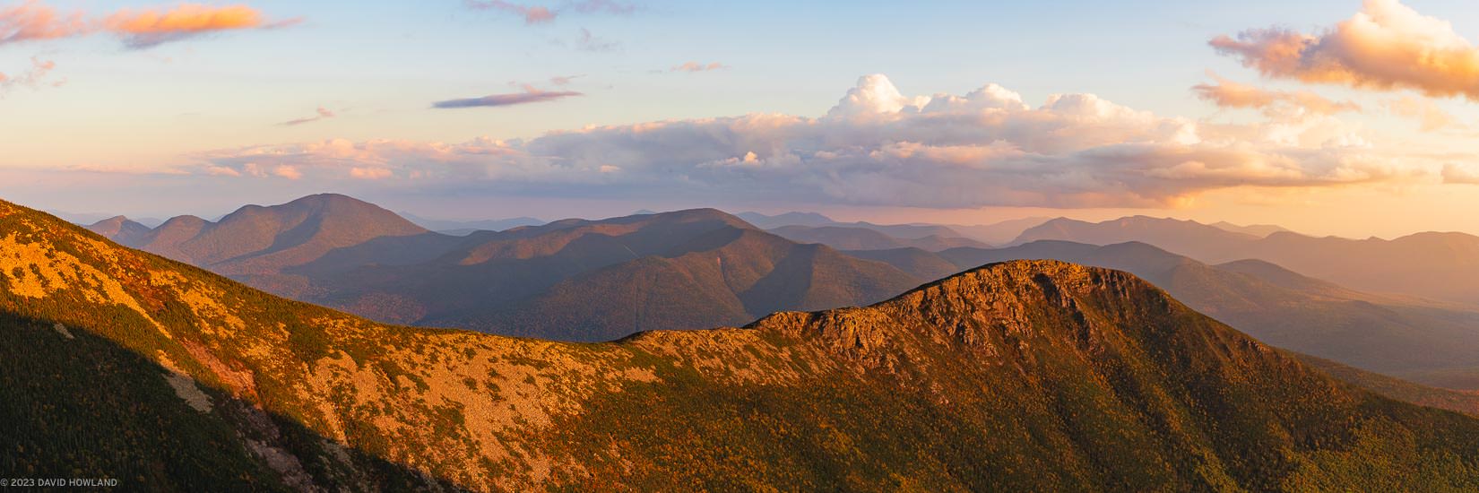 A panoramic photo of the rocky ridgeline of Bondcliff bathed in golden sunset light.