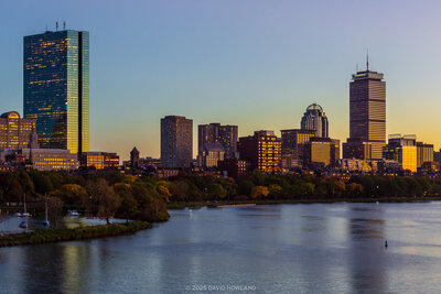 A panorama photo of the illuminated buildings of the Back Bay neighborhood of Boston at sunset.
