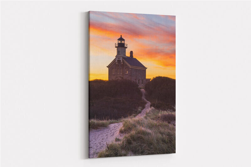 A photo of colorful clouds silhouetting North Lighthouse on Block Island at sunrise