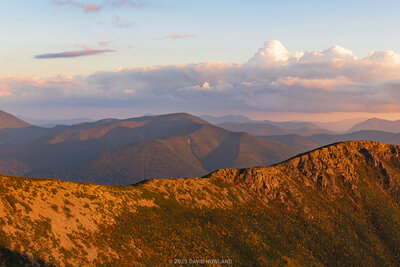 A panoramic photo of the rocky ridgeline of Bondcliff bathed in golden sunset light.