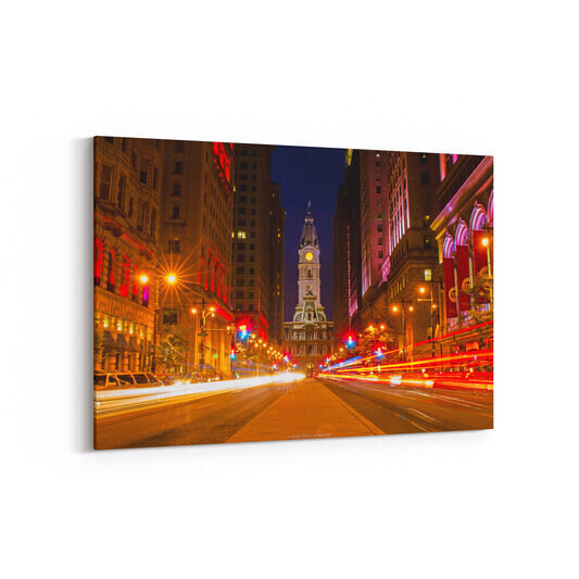 A photo of Broad Street in Center City Philadelphia with the tower of City Hall rising over the median walkway bisecting the busy roadway