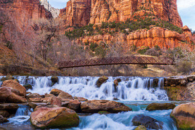 A photo of a waterfall in front of the towering rock walls of Zion National Park in Utah.