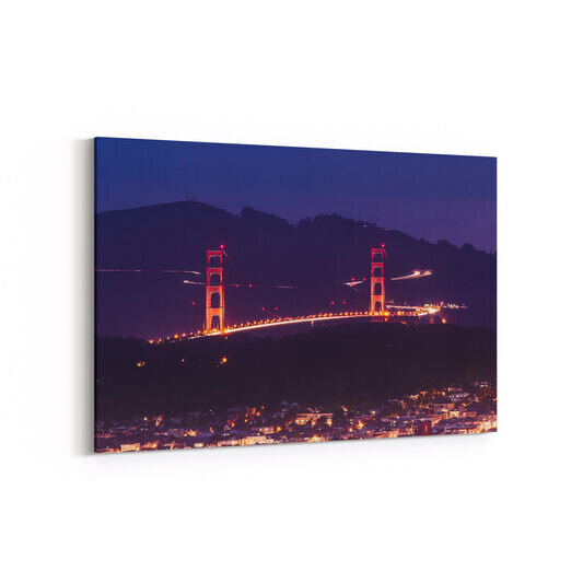 A long exposure photo of the Golden Gate Bridge taken from Twin Peaks with the streams of traffic in the Marin Headlands visible behind the bridge.