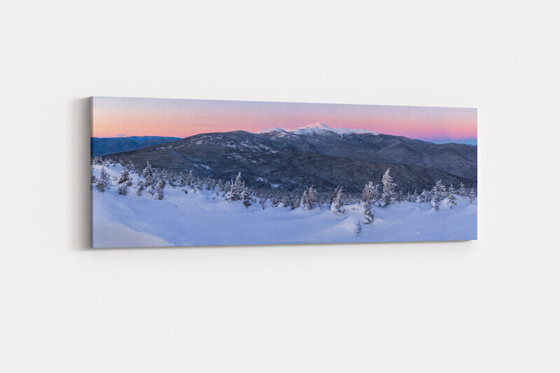 A panoramic winter sunset view from Mount Jackson in New Hampshire's Presidential Range, showing deep snow drifts and snow-laden evergreen trees in the foreground, with Mounts Eisenhower, Pierce, and Monroe visible across dark forested ridges, and snow-capped Mount Washington rising prominently against a glowing pink and lavender twilight sky.