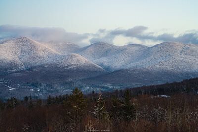 A photo of the snow covered Cannonballs and Cannon Mountain at dusk