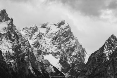 A black and white photo of storm clouds gathering over the snowy high peaks of the Teton Range in Grand Teton National Park, WY.