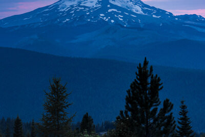 A photo of sunset behind the snow covered slopes of Mount Hood in Oregon.